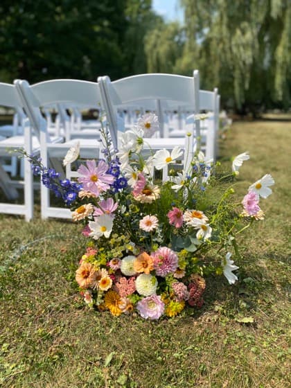 A lush floral arrangement marking a ceremony aisle
