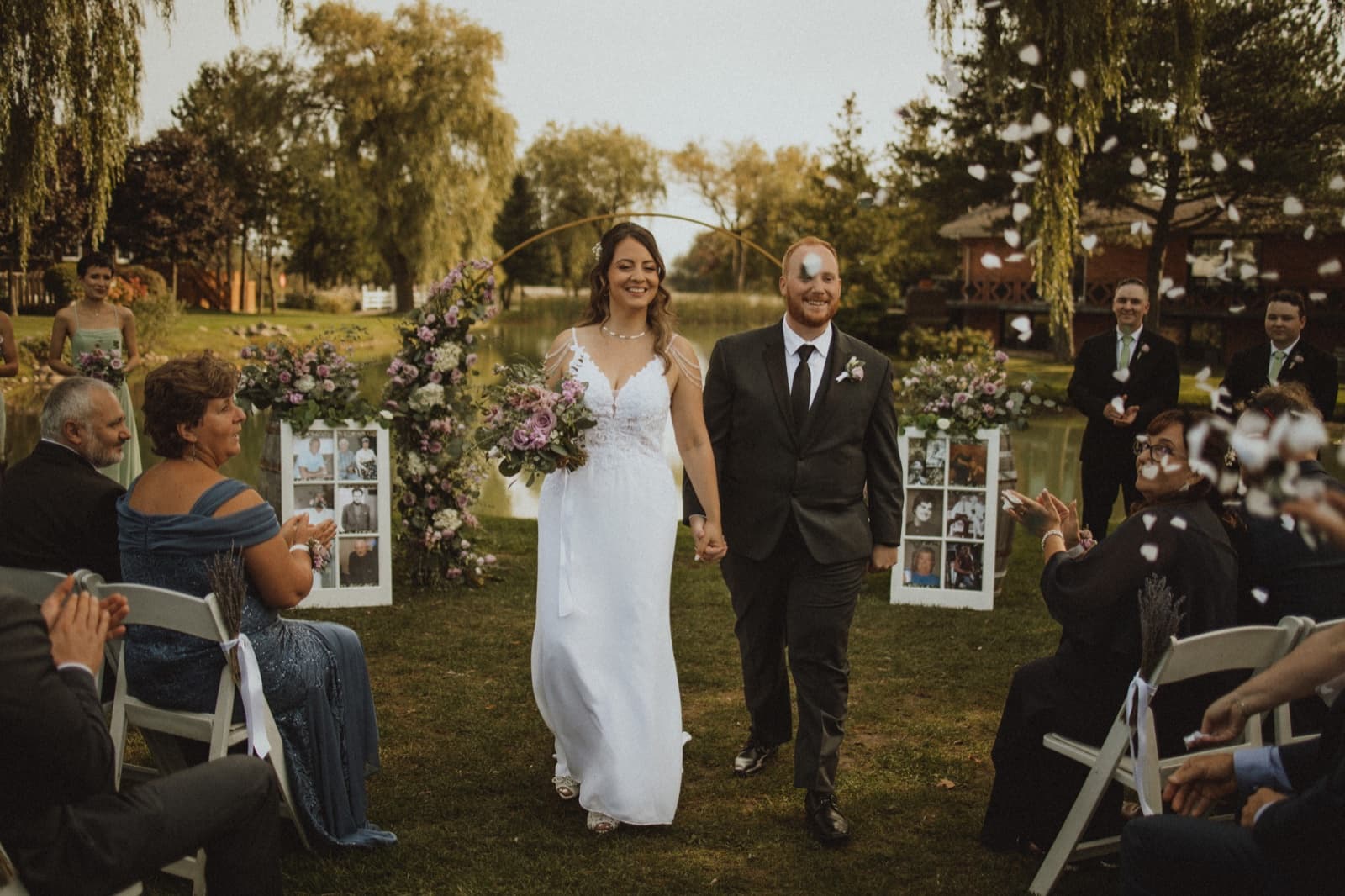 Newlyweds walking back up the aisle through tossed petals